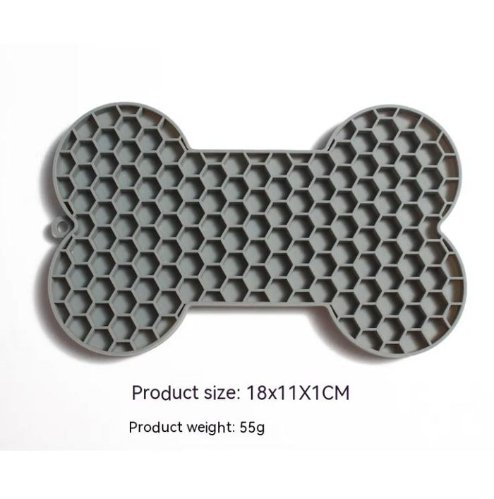 Gray bone-shaped silicone dog slow feeder lick mat with raised honeycomb texture, size 18 x 11 x 1 cm and weight 55 g shown on image