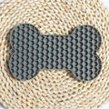 Gray bone-shaped silicone dog slow feeder lick mat with raised honeycomb texture, size 18 x 11 x 1 cm and weight 55 g shown on image